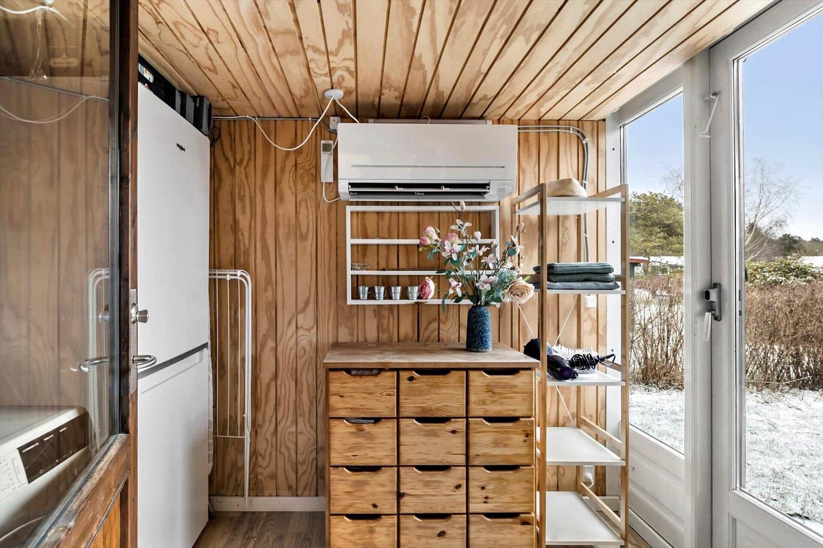 Küche mit Holzwand, Kühlschrank und Holzschubladen.