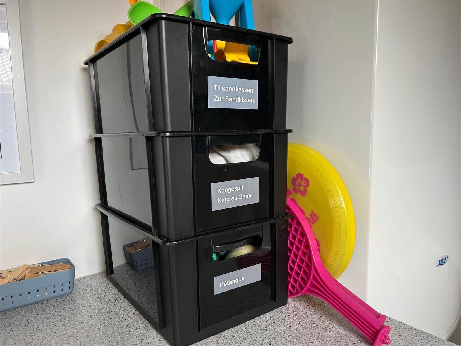 Black boxes with toys for sandbox, king es game, and pétanque.