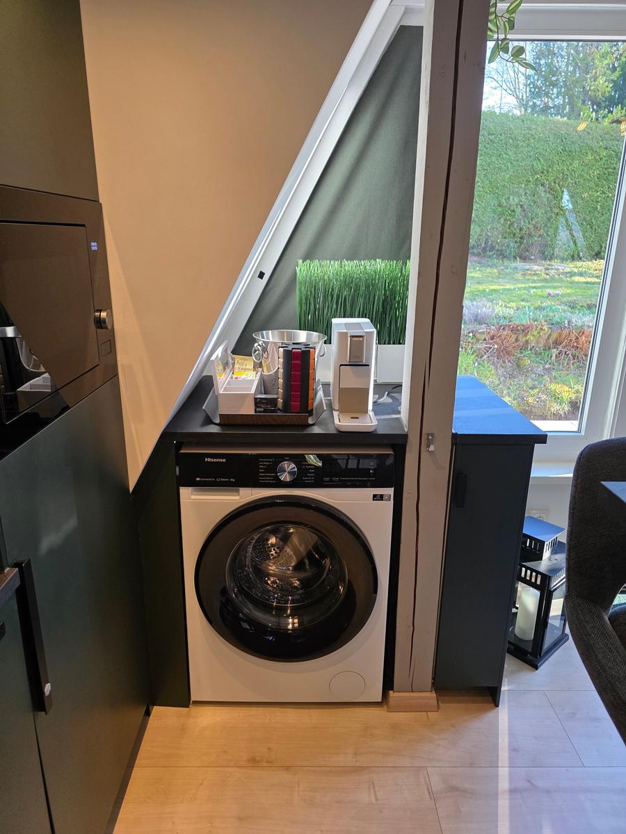 Waschmaschine unter Fenster mit Gartenblick