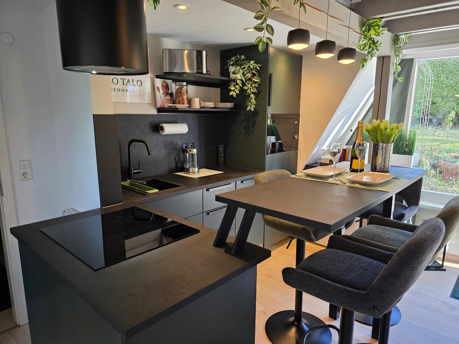 Moderne Küche mit Esstisch und Blick auf Garten