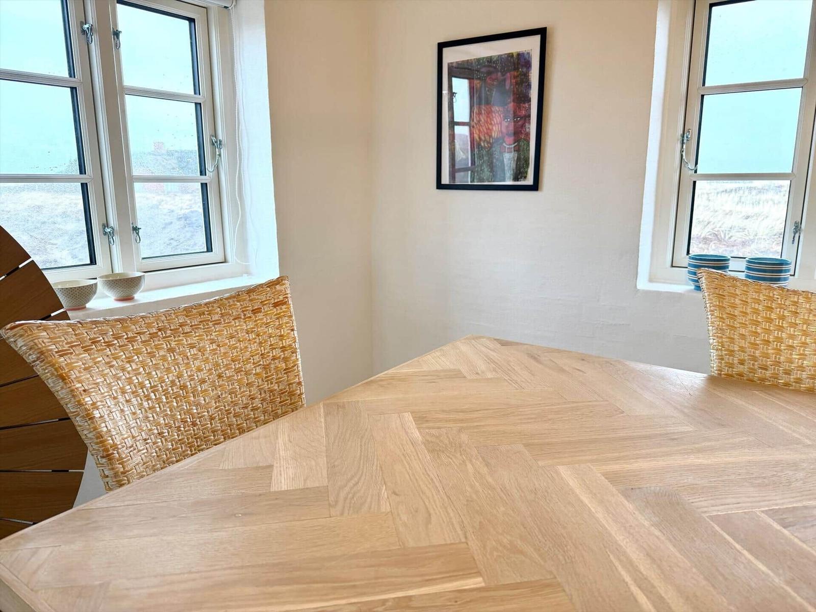 Esszimmer mit Holztisch, Stühlen und Fenstern
