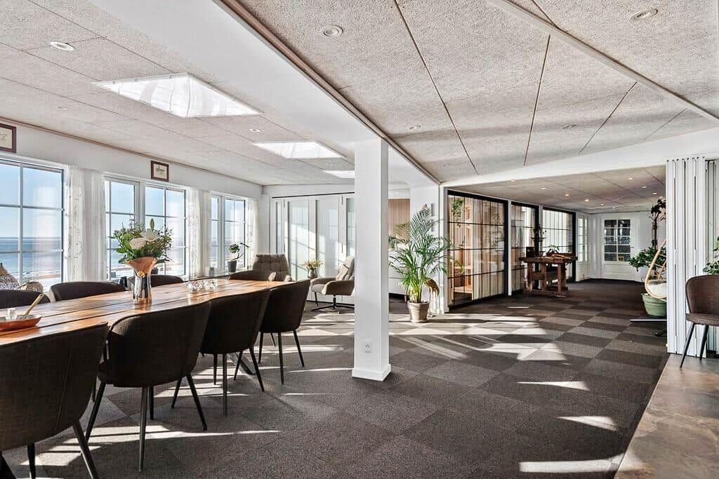 Large space with dining area, windows, and sea view.