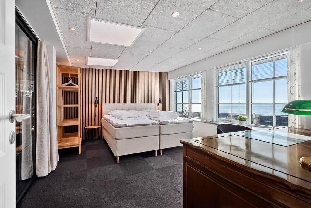 Bedroom with sea view, bed, wardrobe, and desk.