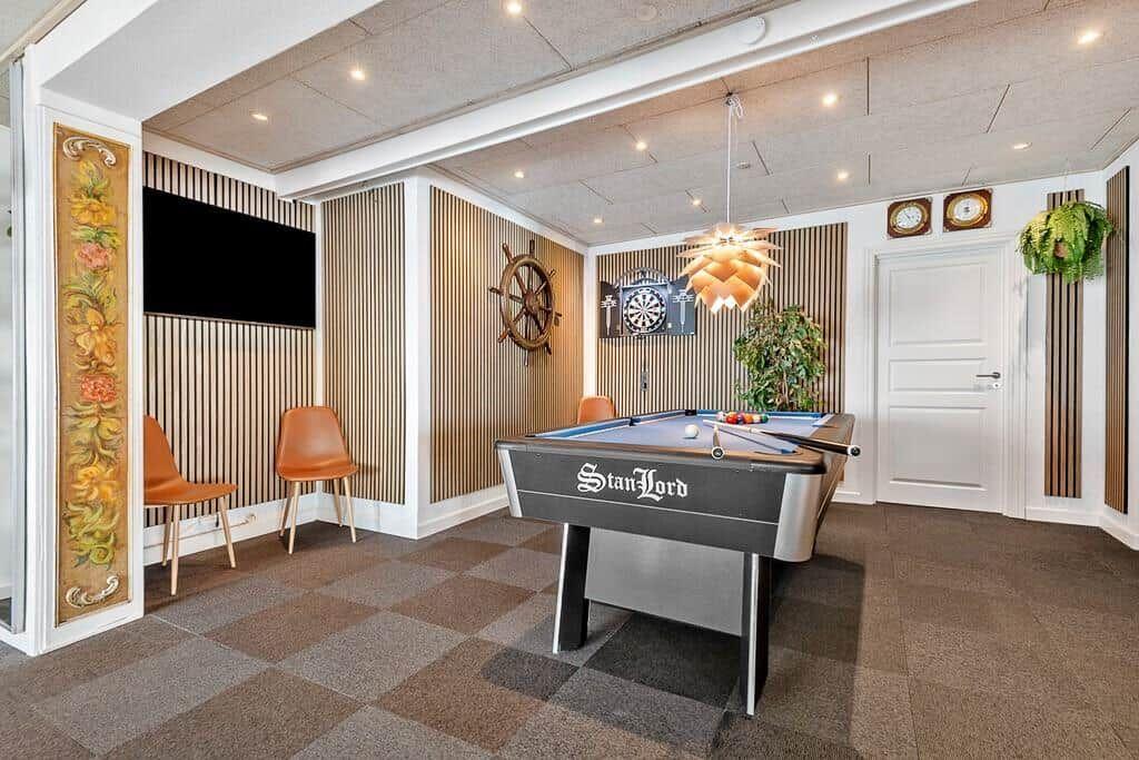 Room with pool table, TV, and dartboard on the wall.