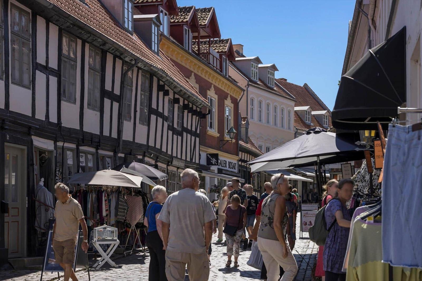 Straße mit Fachwerkhäusern und Menschen auf Kopfsteinpflaster