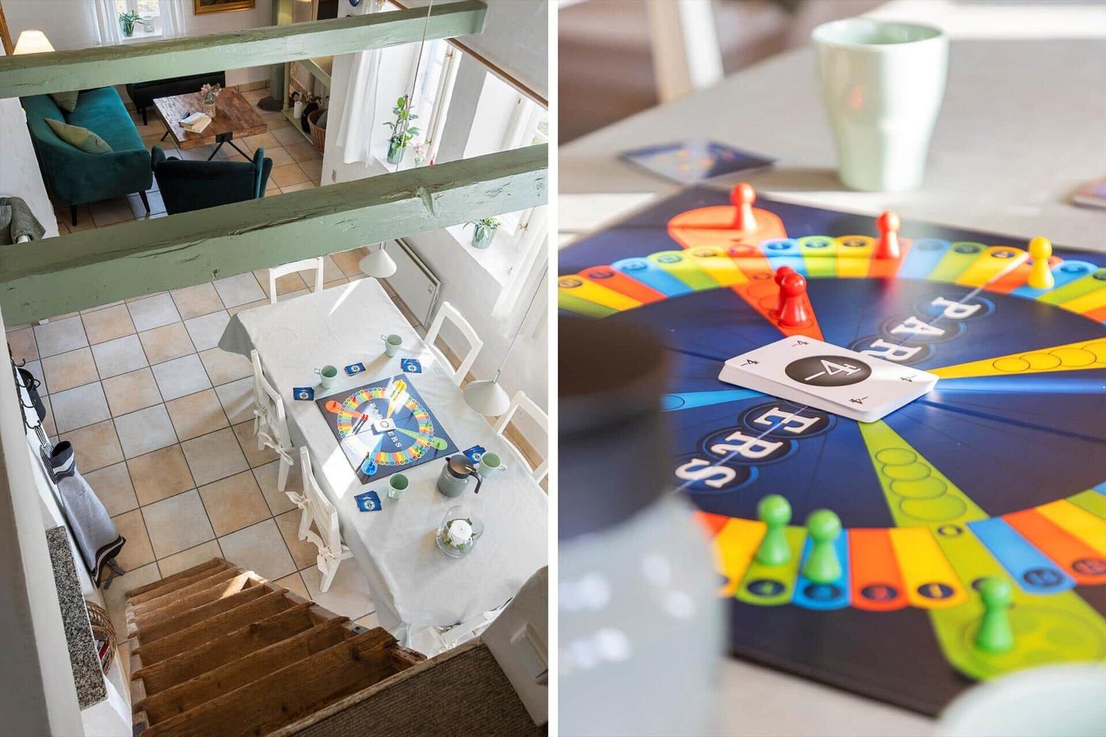 Esszimmer mit Tisch und Stühlen. Spielbrett mit Figuren und Karten auf Tisch.