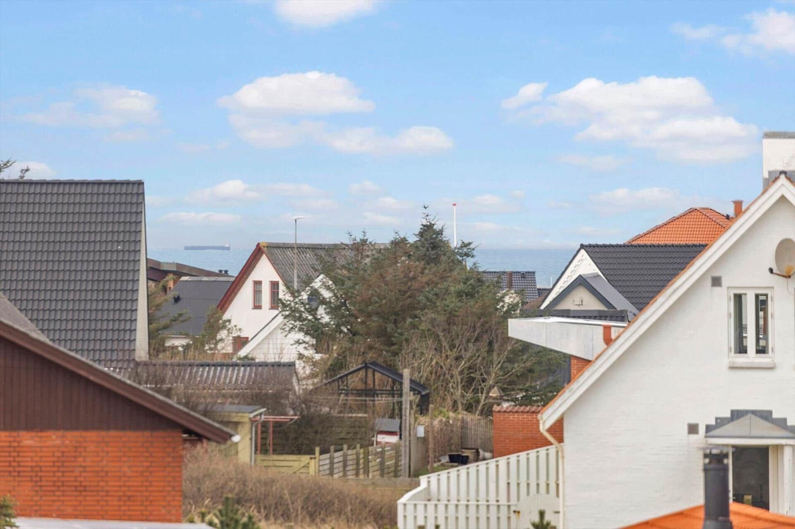Haus mit Blick auf Meer und Himmel mit Wolken.