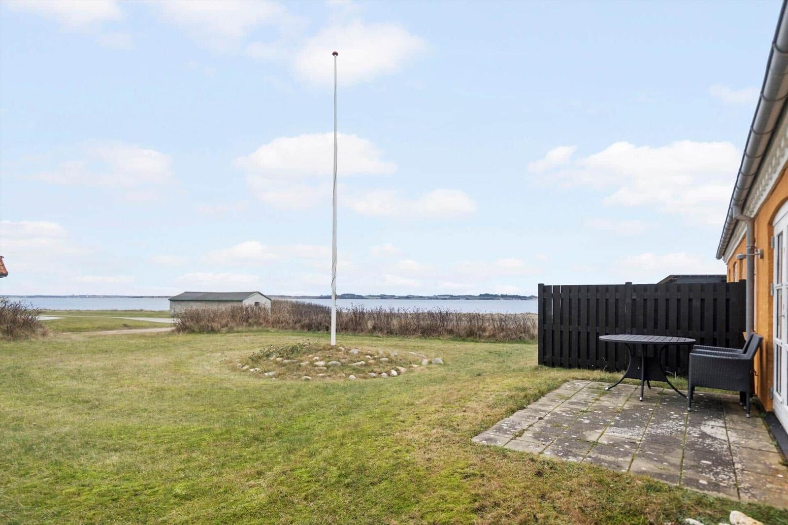 Hinterhof mit Tisch, Stuhl und Blick auf Wasser
