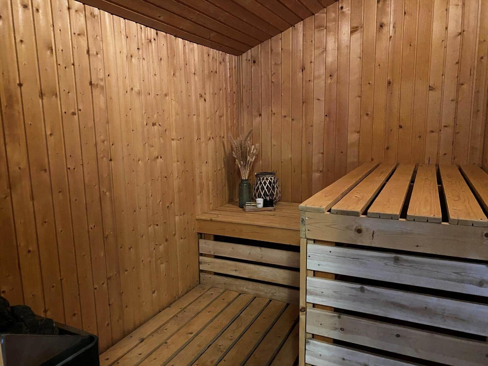 Sauna with wooden walls, benches, and decorative items.