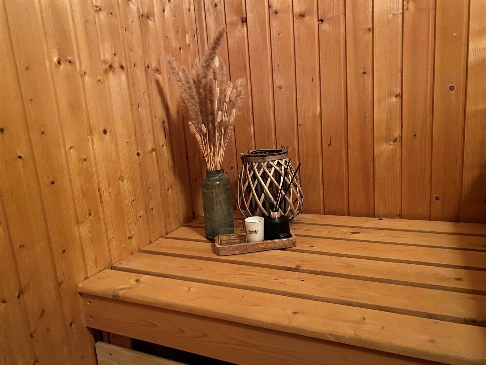 Wooden bench in sauna with vases and aroma candles
