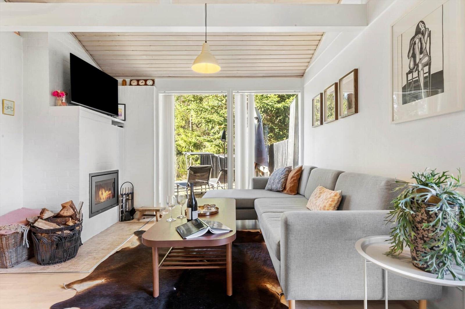 Living room with sofa, fireplace, and balcony view