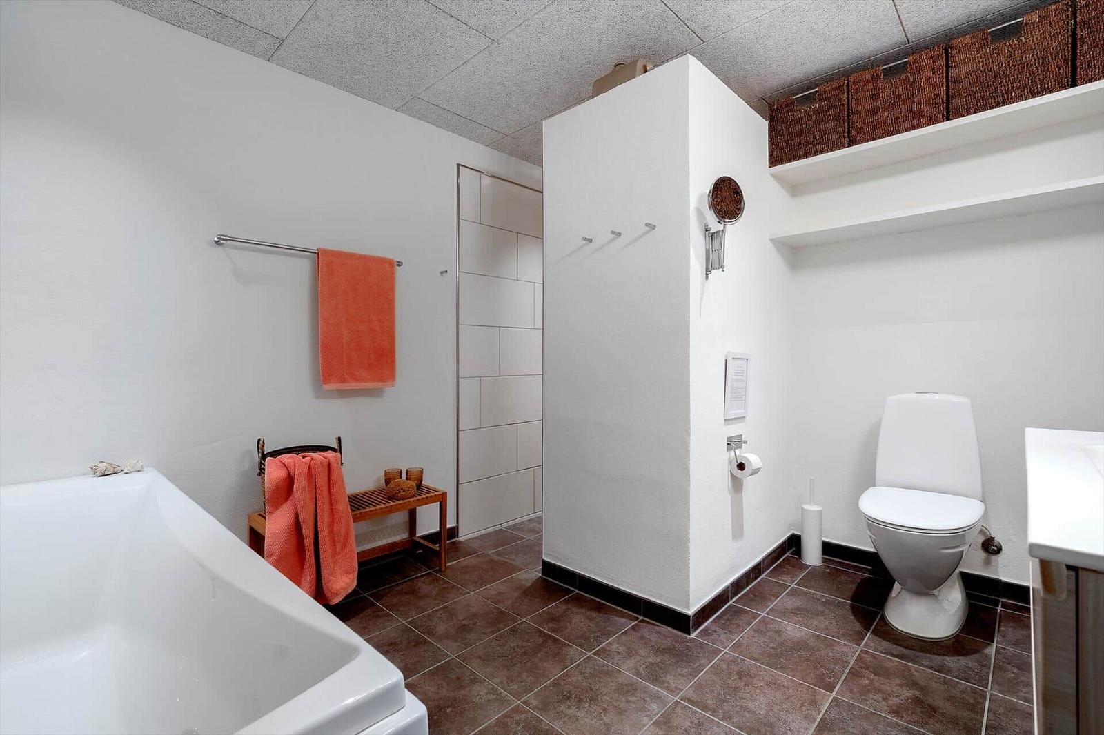 Bad mit Badewanne, Dusche, Toilette und Handtuchhalter.