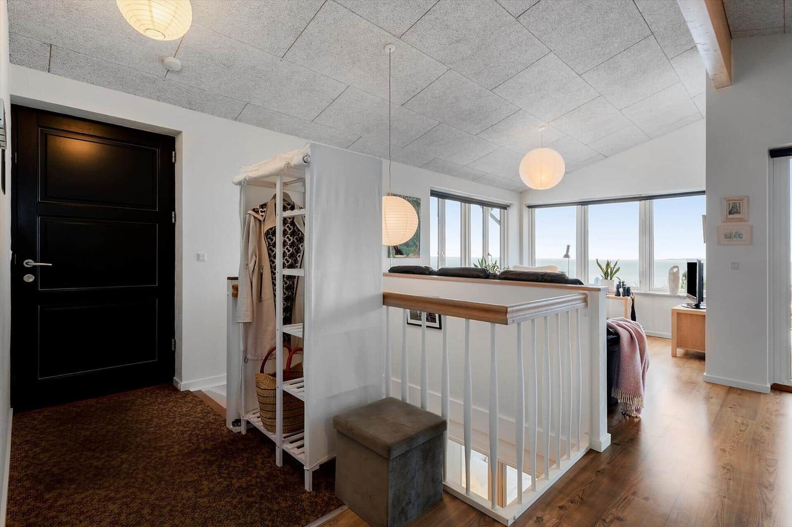 Eingangsbereich mit Kleiderschrank und Blick in Wohnbereich mit Fenster.