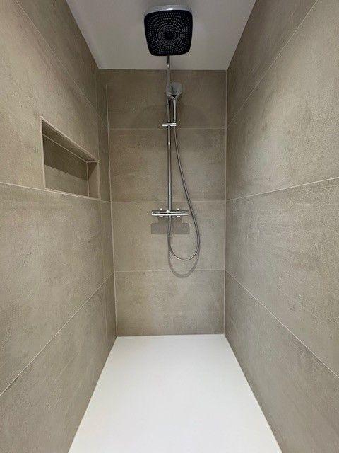 Duschkabine mit Duschbrause und eingebauter Ablage