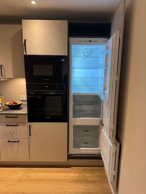 Küche mit Kühlschrank, Backofen und Mikrowelle