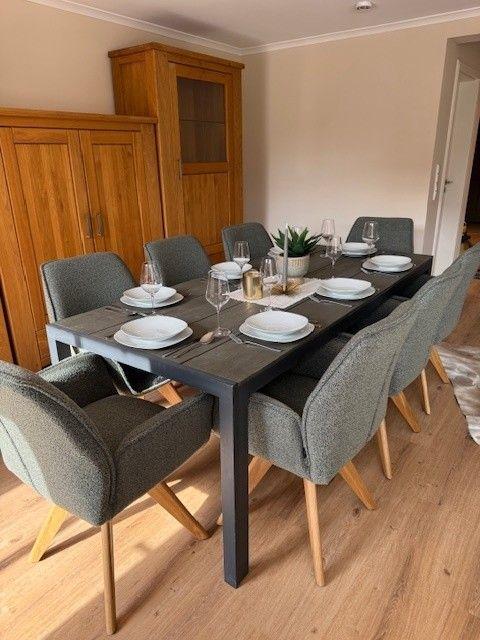 Esszimmer mit Tisch, sechs Stühlen und Holzmöbeln.