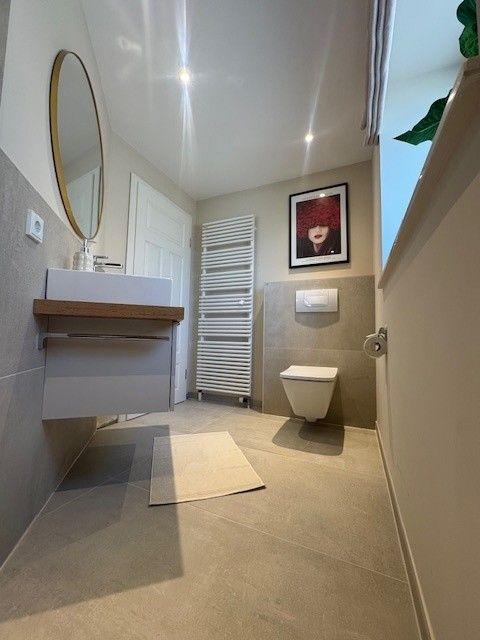 Badezimmer mit Waschbecken, Toilette und Heizkörper