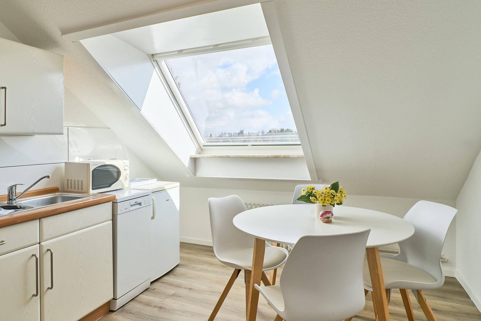 Küche und Essbereich mit Dachfenster und Tisch für vier Personen.