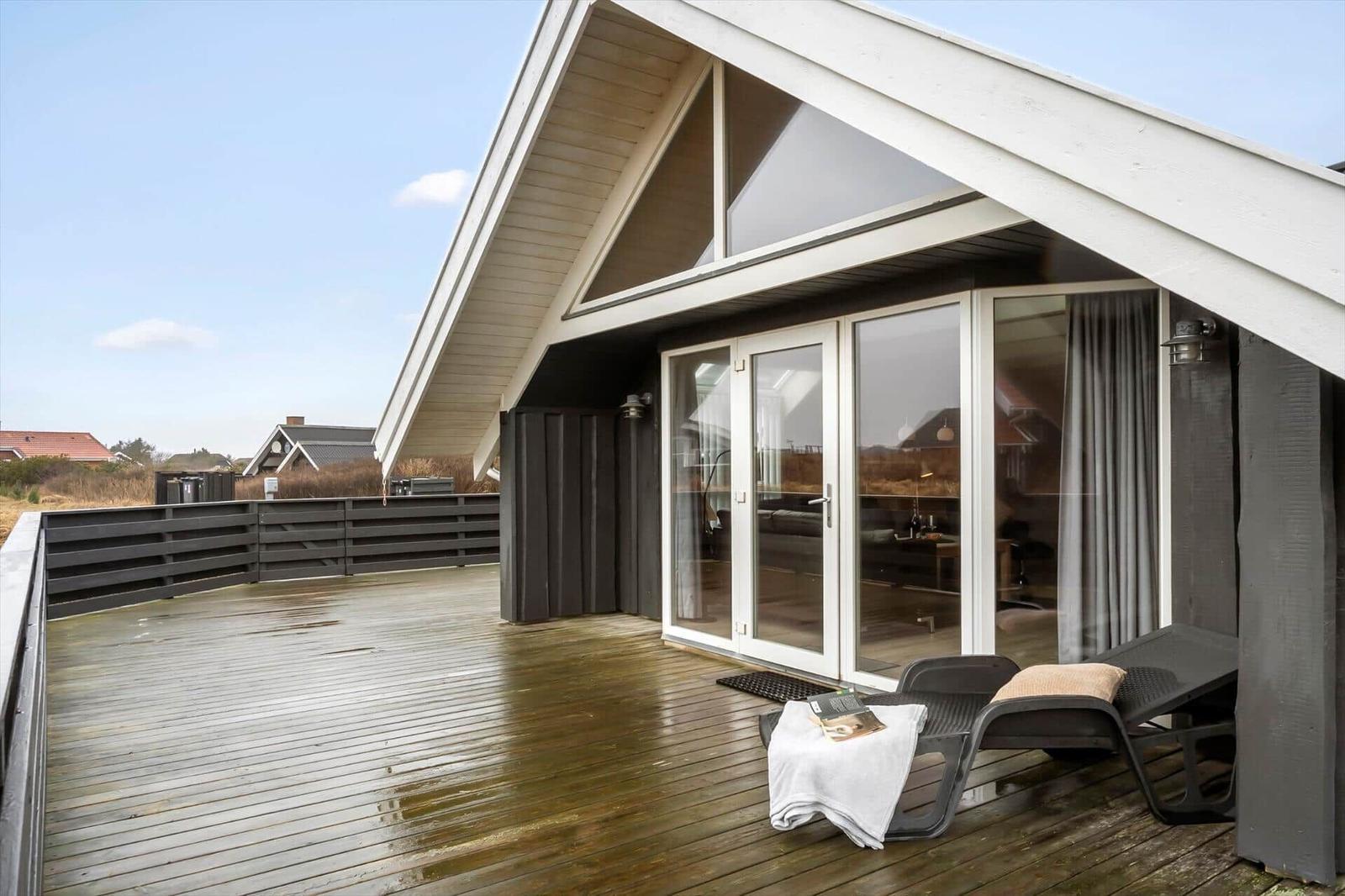 Terrasse mit Liegestühlen und Blick in das Haus