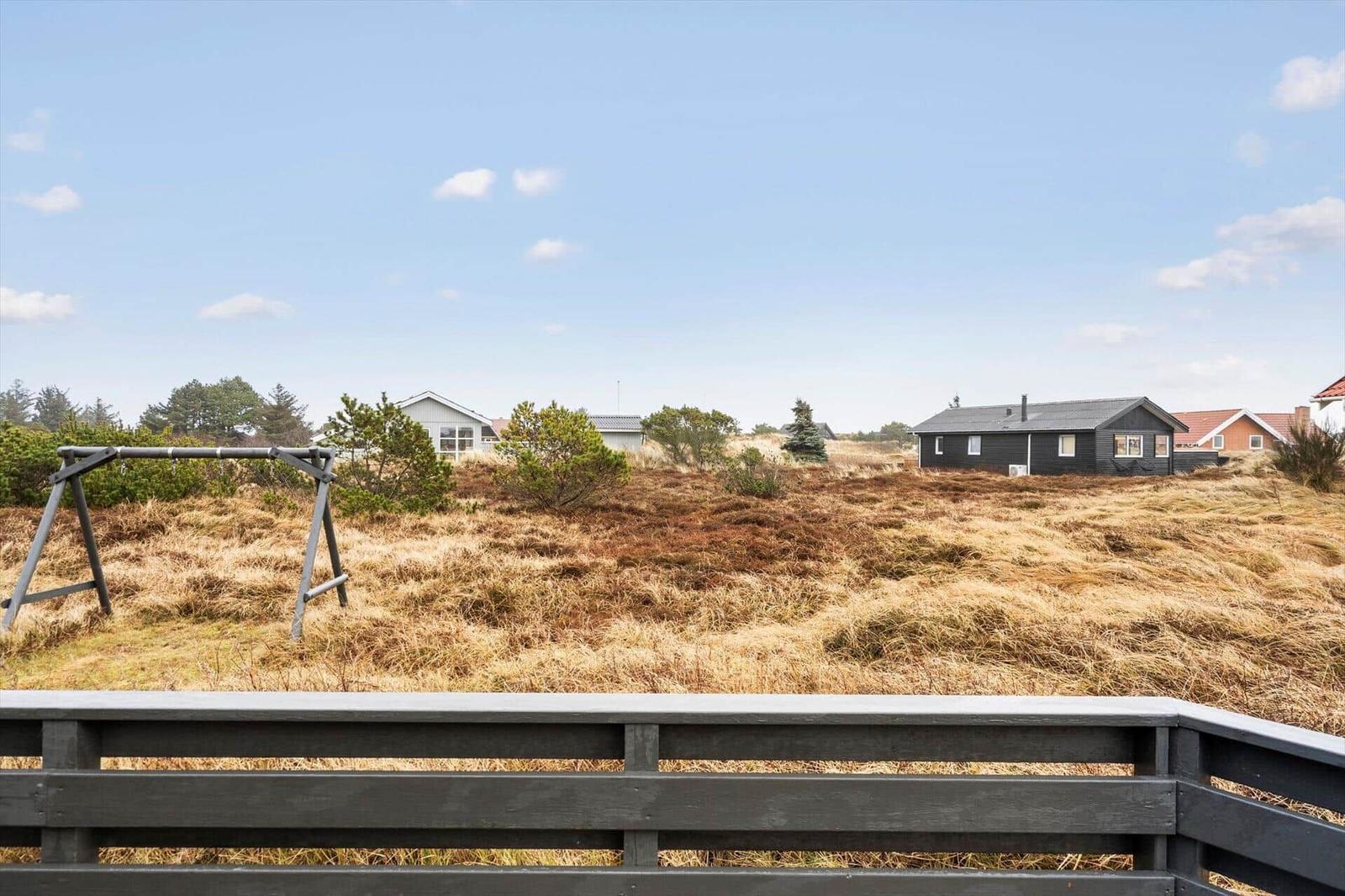 Villa mit Blick auf grasiges Terrain und Bäume unter blauem Himmel