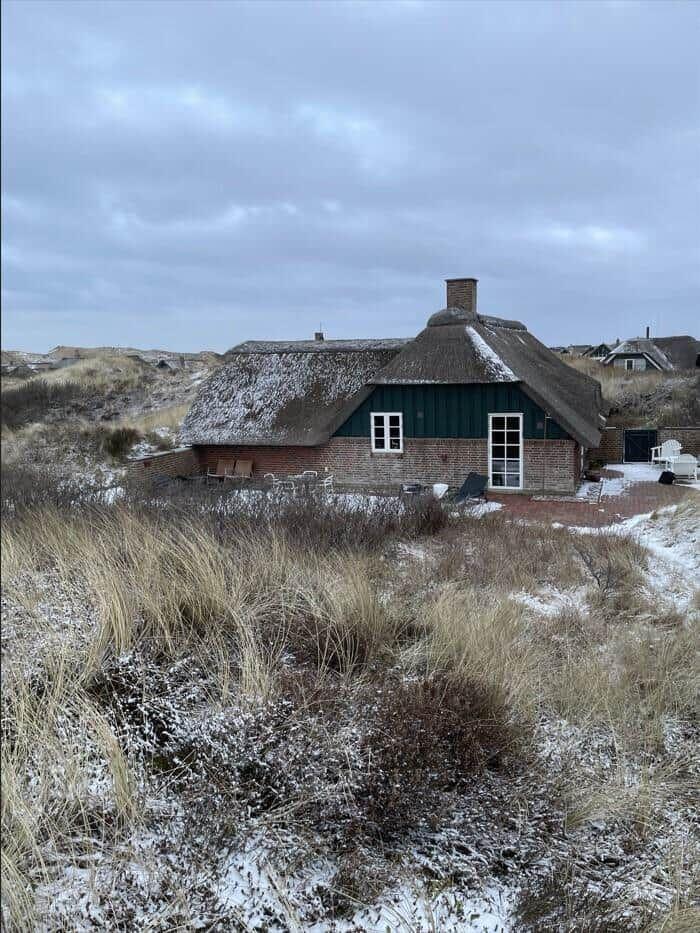 Haus mit Strohdach und Schnee auf Dünen