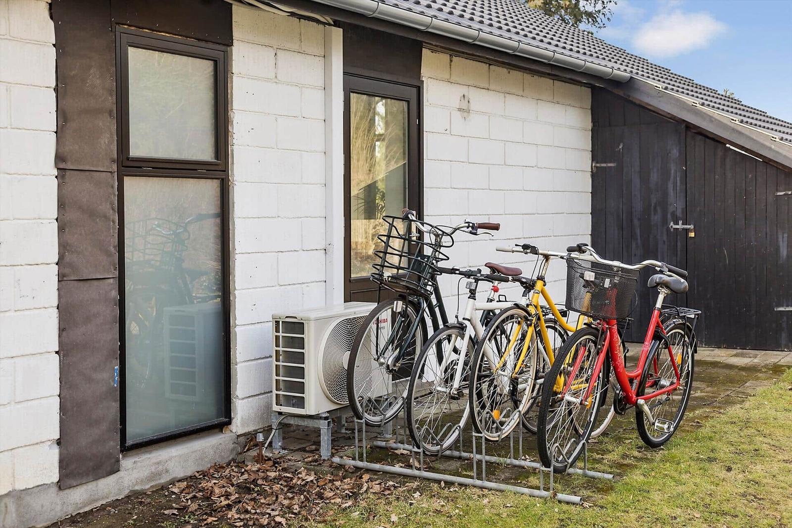Vor dem Haus stehen mehrere Fahrräder und ein Klimagerät.
