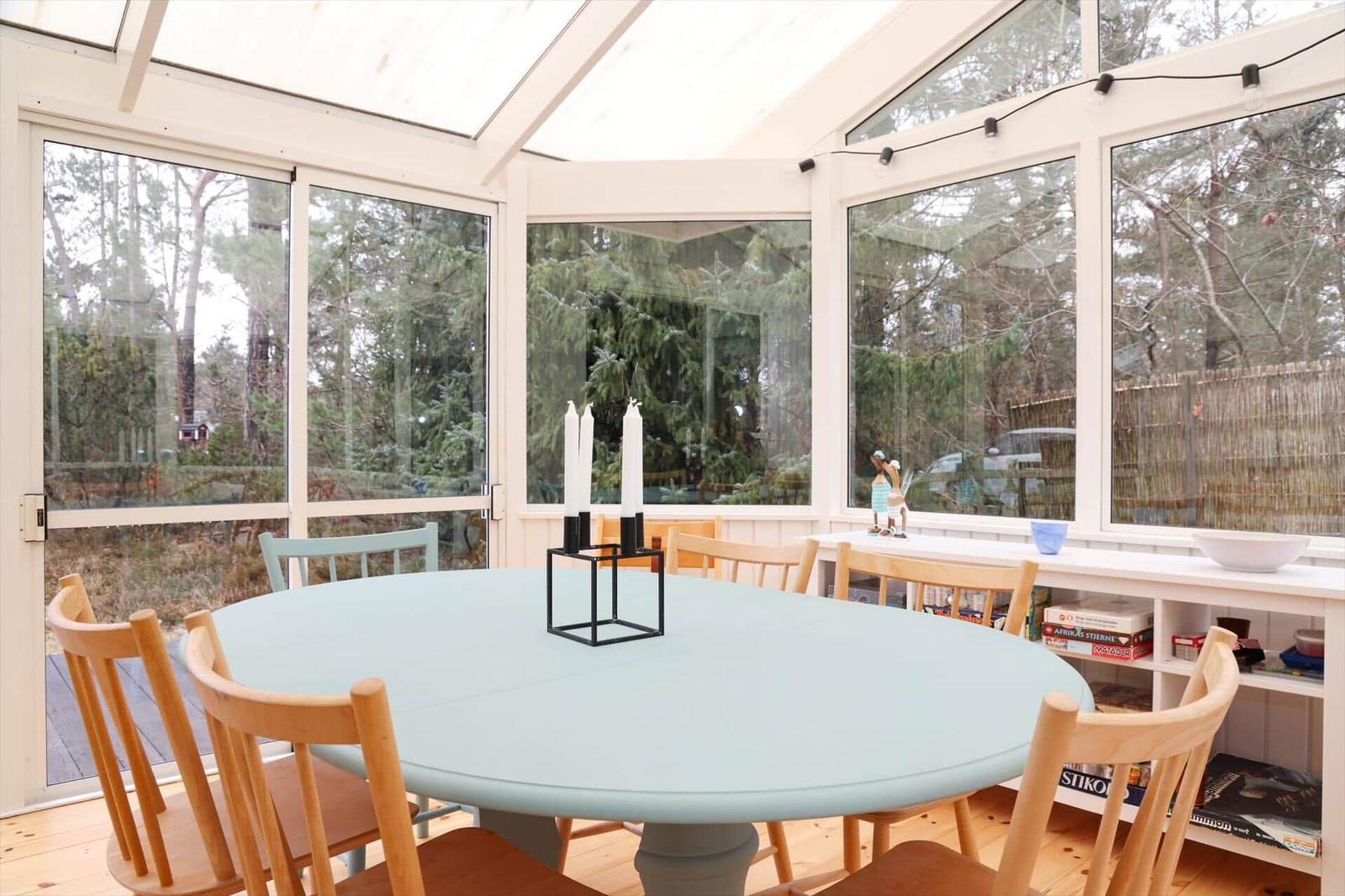 Round table with chairs in a spacious room with large windows.