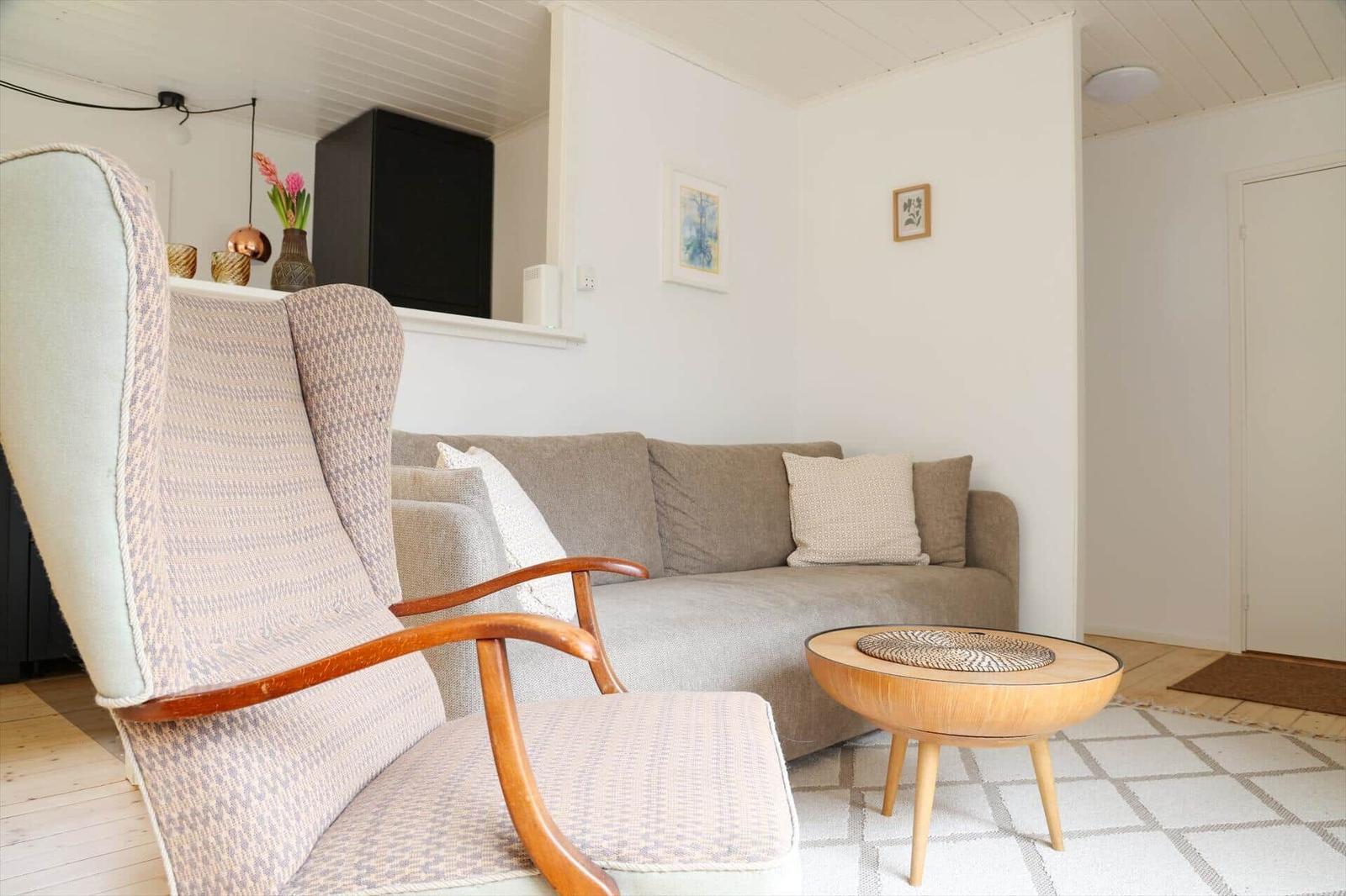 A living room with a chair, a sofa, and a round table.