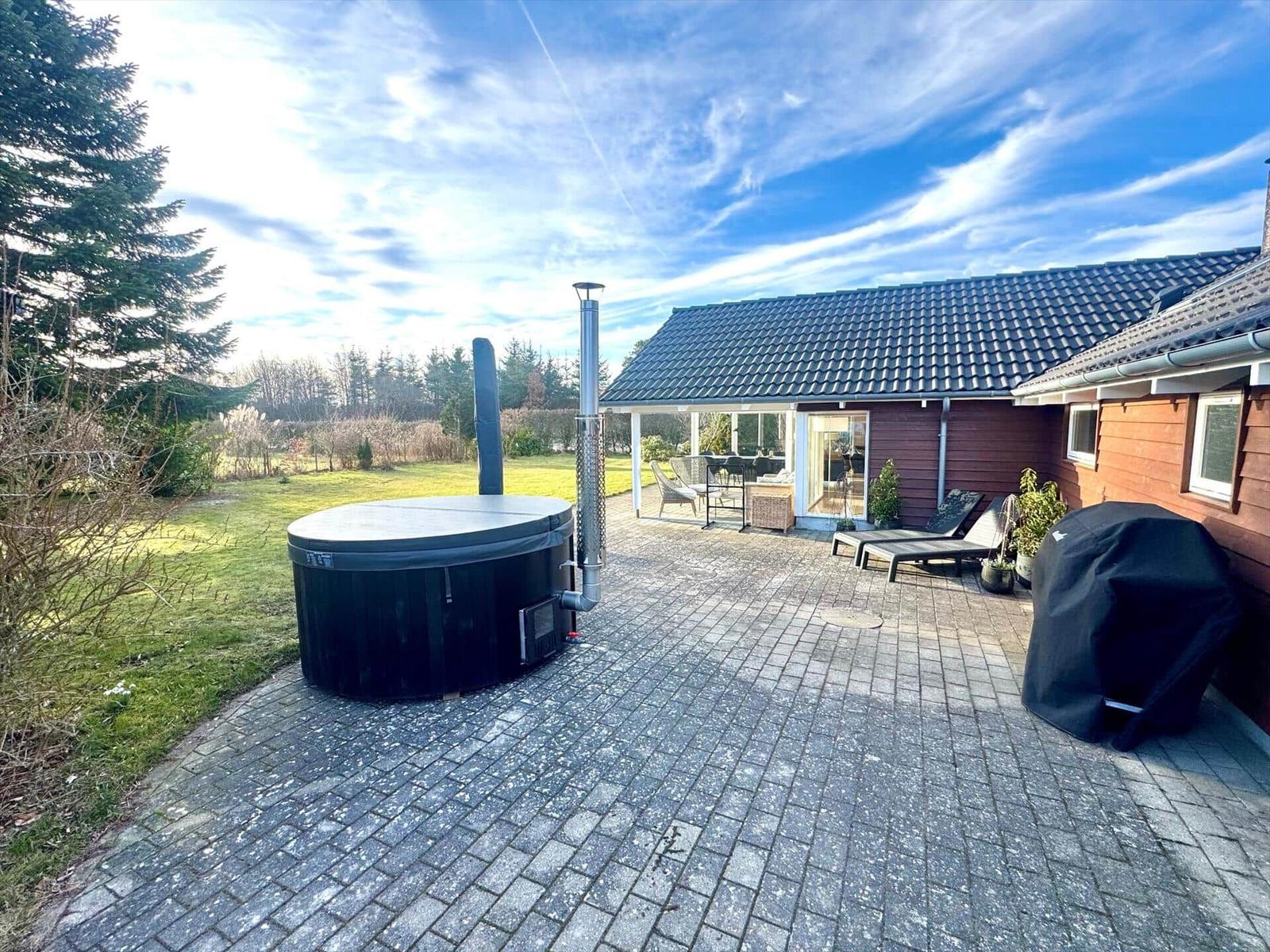 House with terrace, hot tub, and garden.