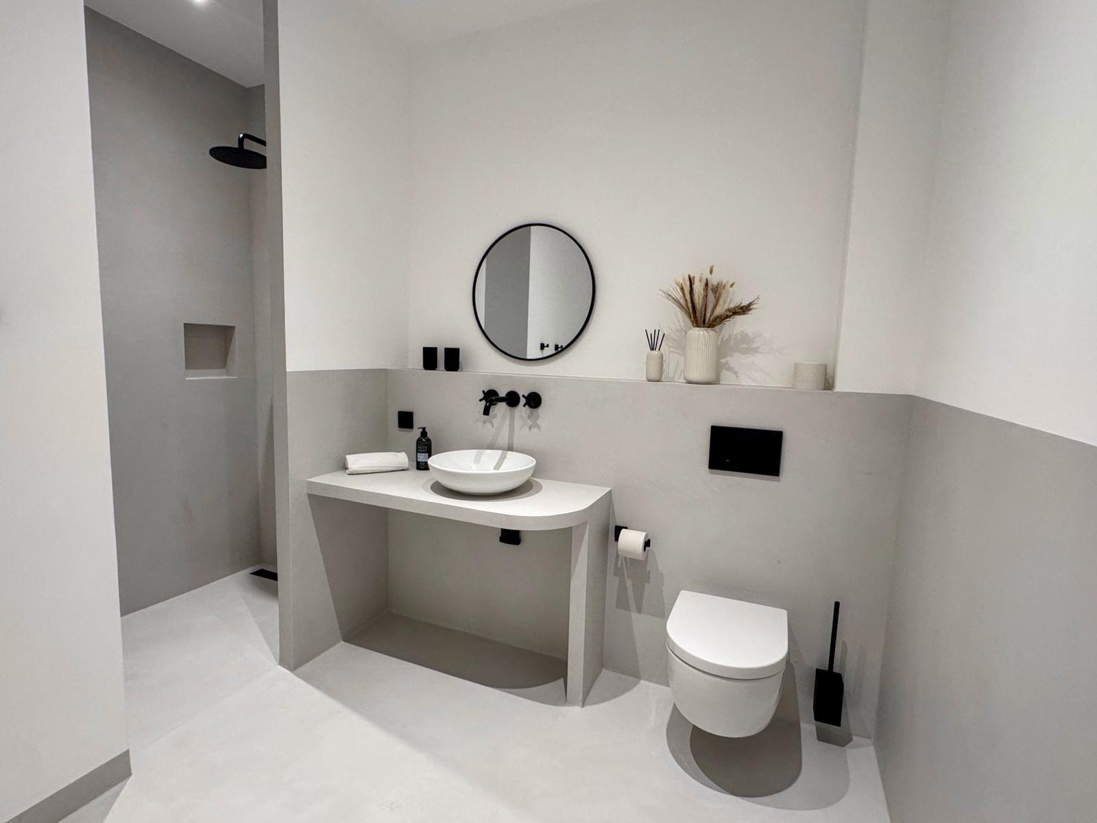 Moderne Dusche, Waschbecken und Toilette in minimalistischem Badezimmer.