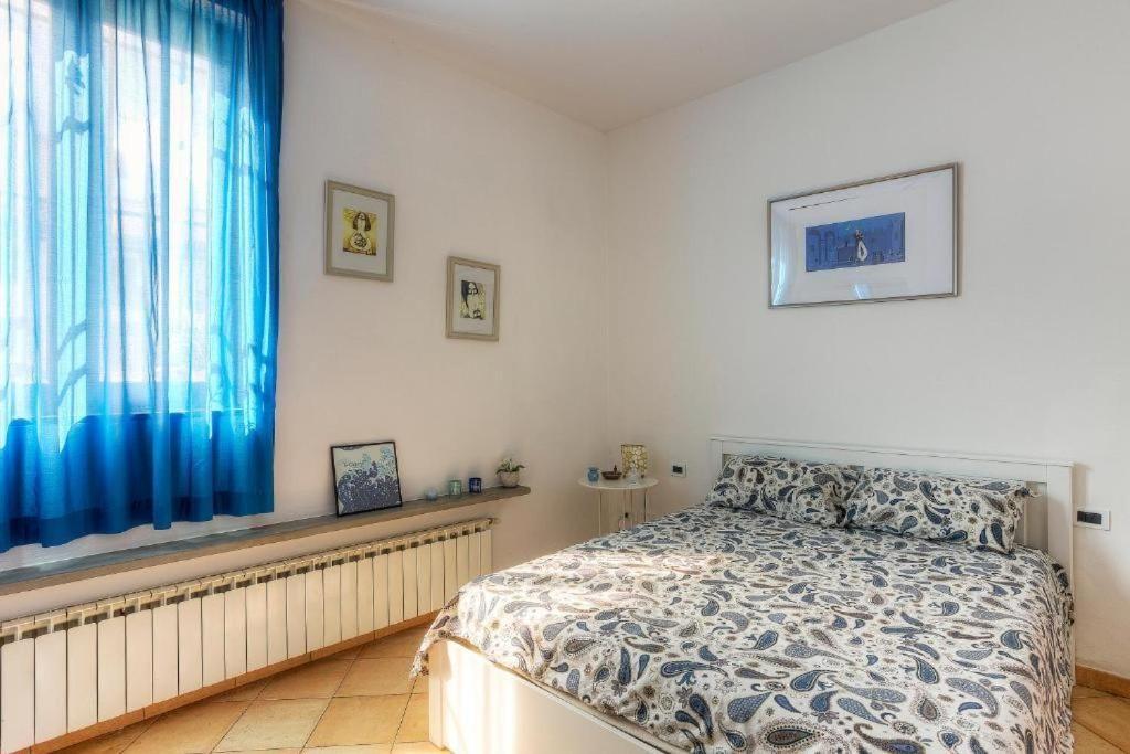 Bedroom with bed, blue curtains, and wall pictures.