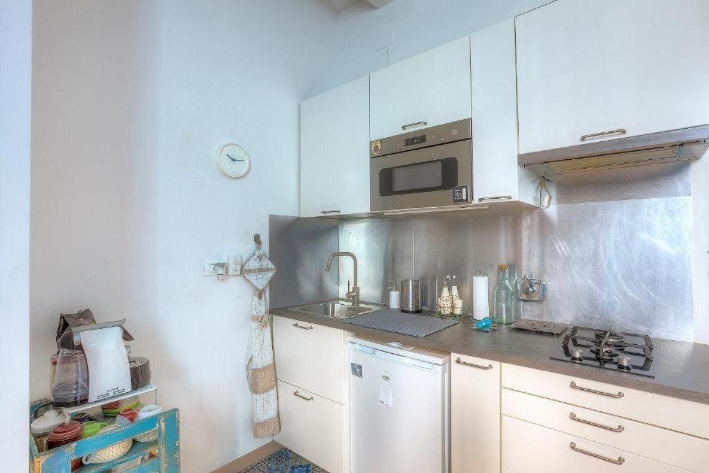 Kitchen with white cabinets, stove, sink, and microwave.