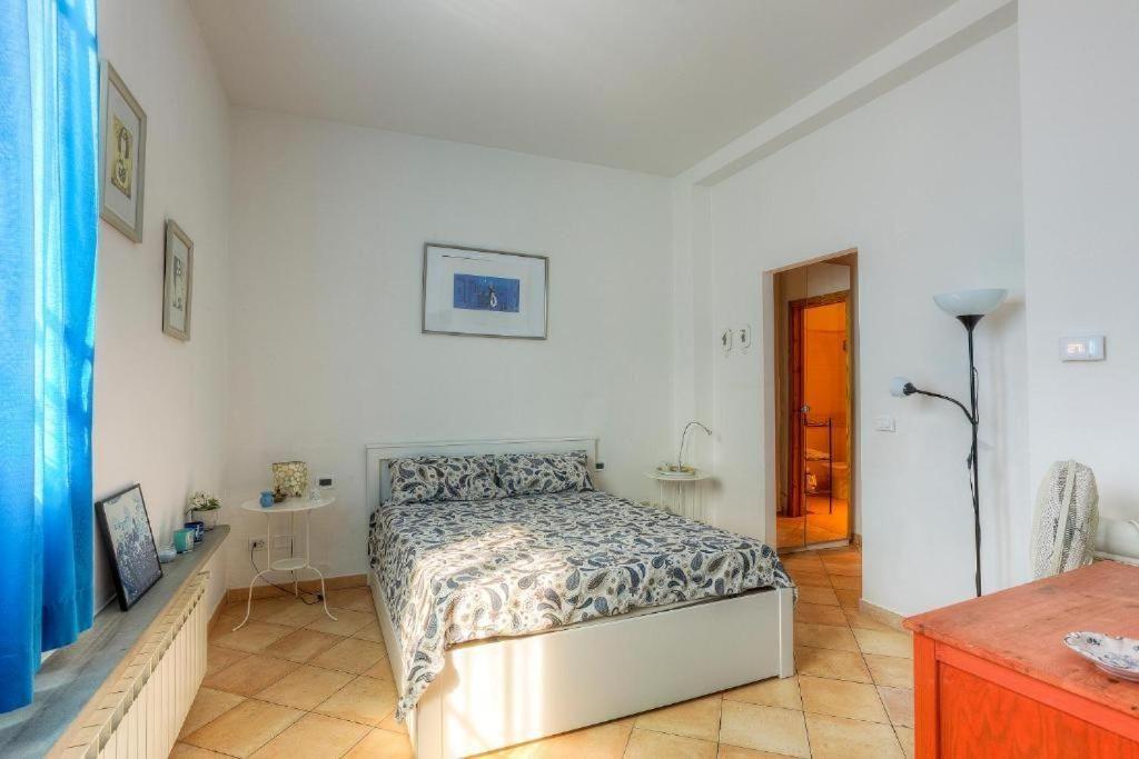 Bedroom with bed, window, pictures, and door to bathroom.