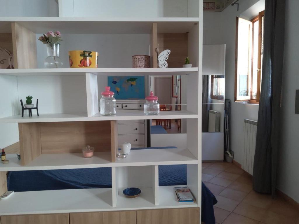 Bedroom with bookcase, bed, and window with curtain.