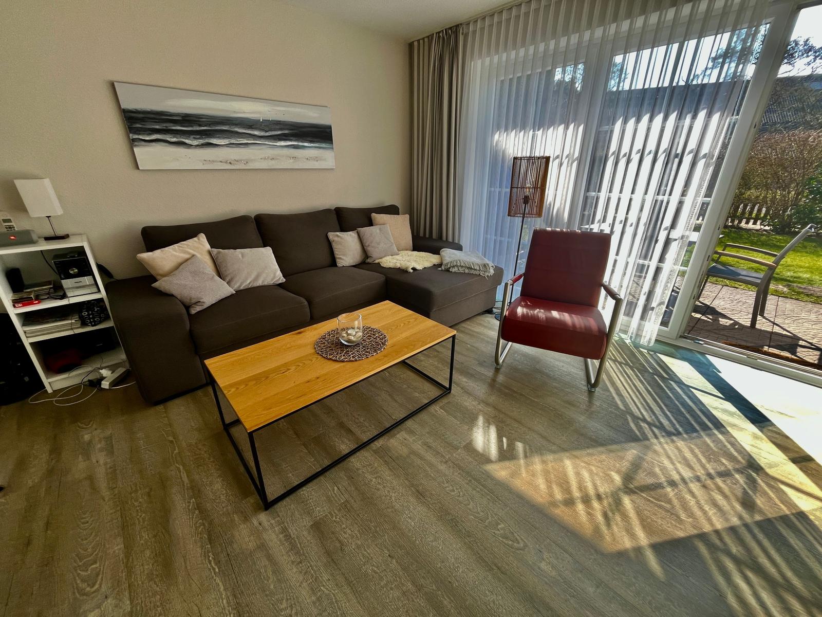 Das Wohnzimmer mit einem gemütlichen Sofa, einem Sessel und einem Couchtisch