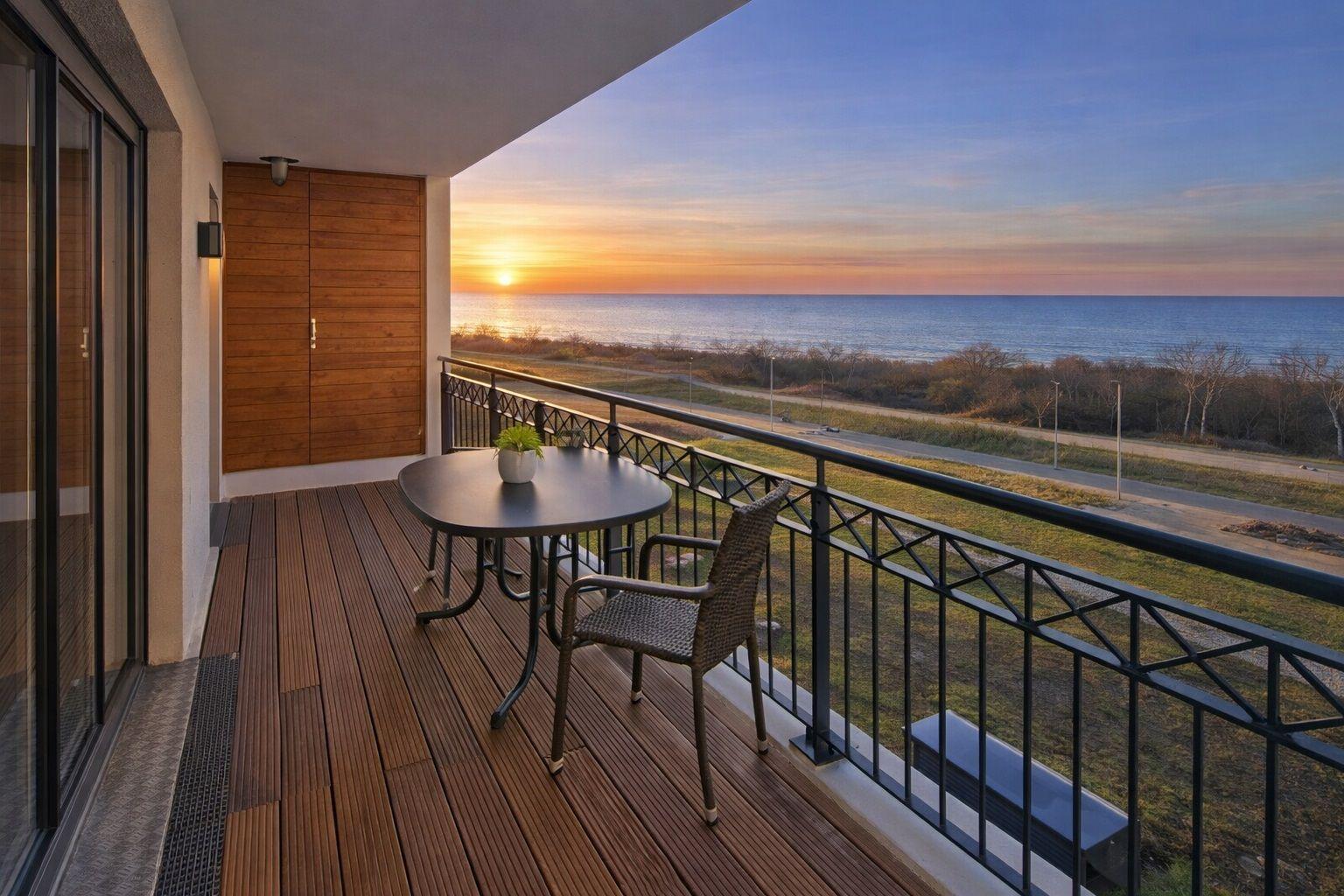 Terrasse mit Tisch und Stühlen bietet Meerblick.