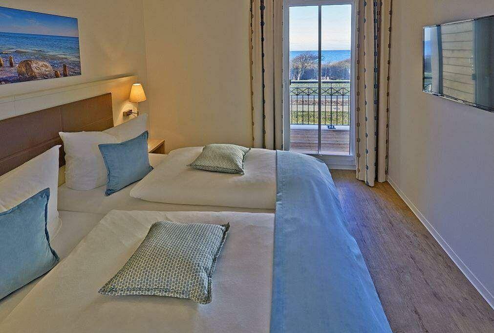 Ein Wohnzimmer mit blauem Sofa, Beistelltisch und Fenster mit Vorhängen.