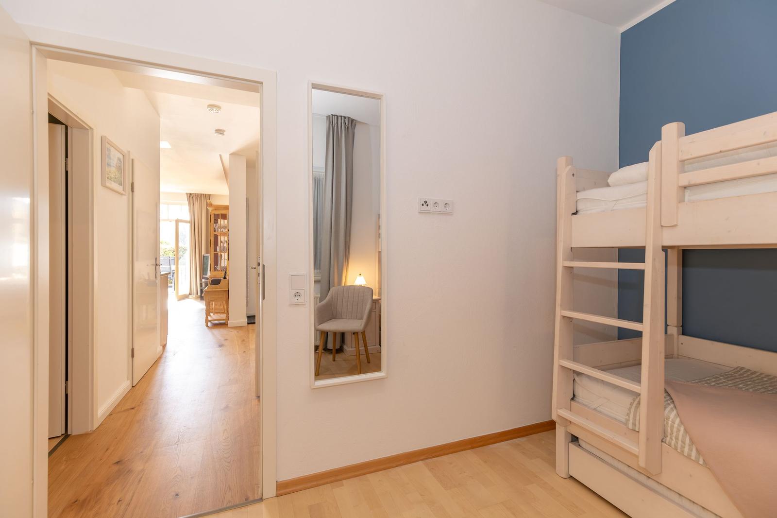 Schlafzimmer mit Bett, Wandbild, Lampe und Fernseher an der Wand.