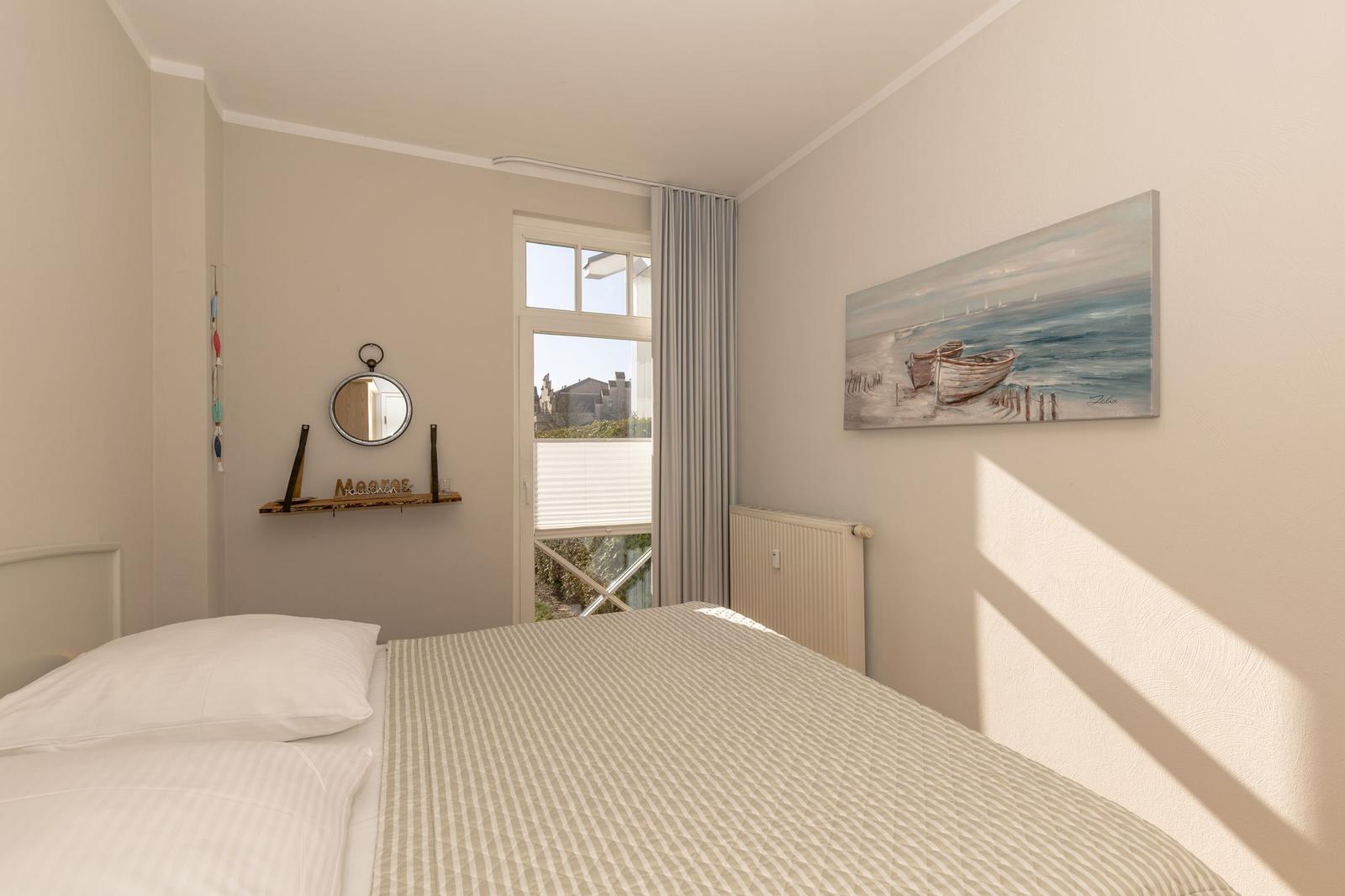 Zimmer mit Doppelstockbett, zwei Sesseln und Fenster mit Vorhängen.