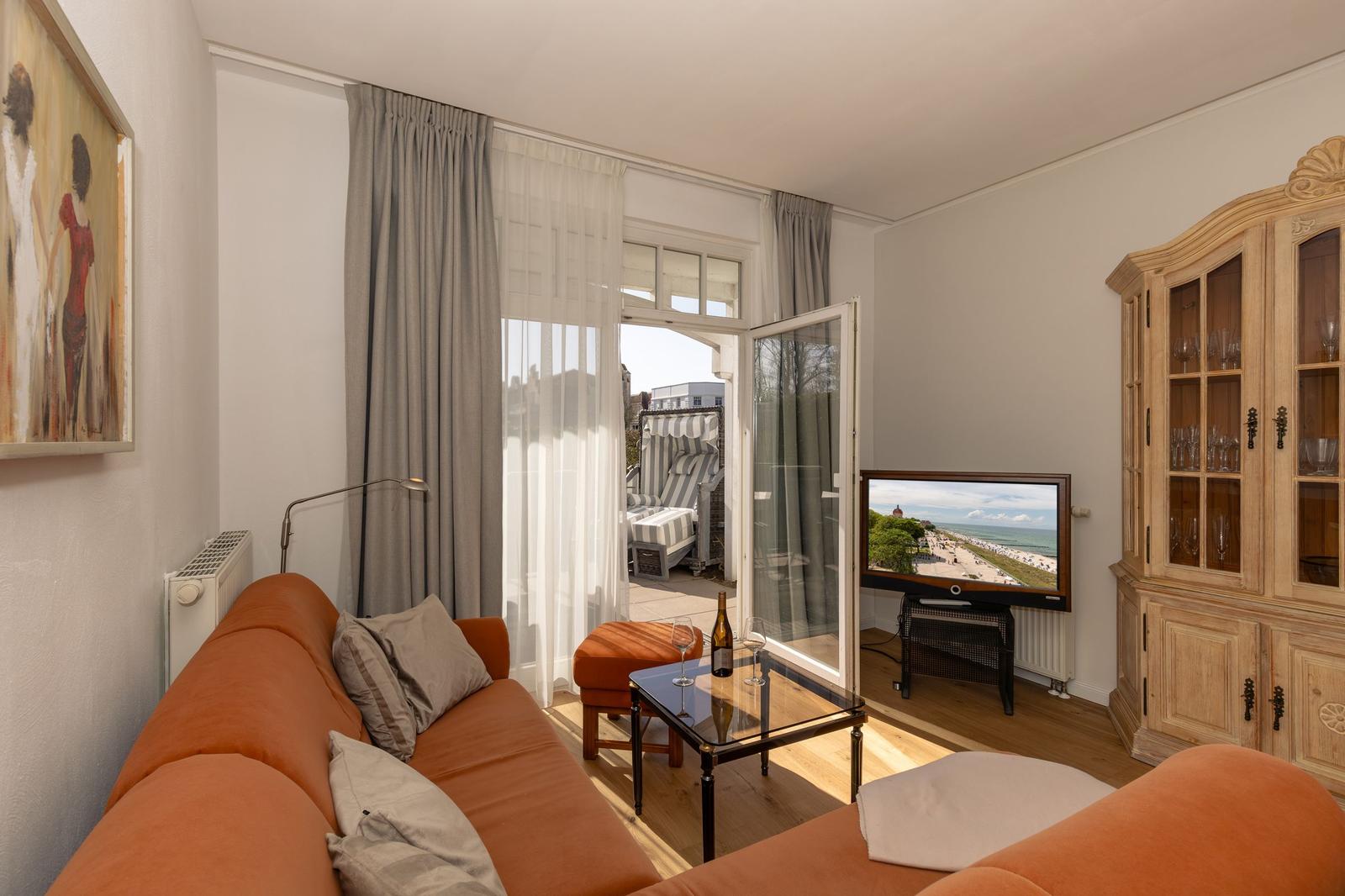 Wohn- und Essbereich mit Sofa, Tisch und Blick auf Garten.