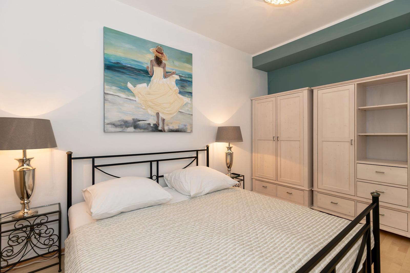 Ein Schlafzimmer mit Doppelstockbett, Nachttisch und Stuhl mit Kissen.