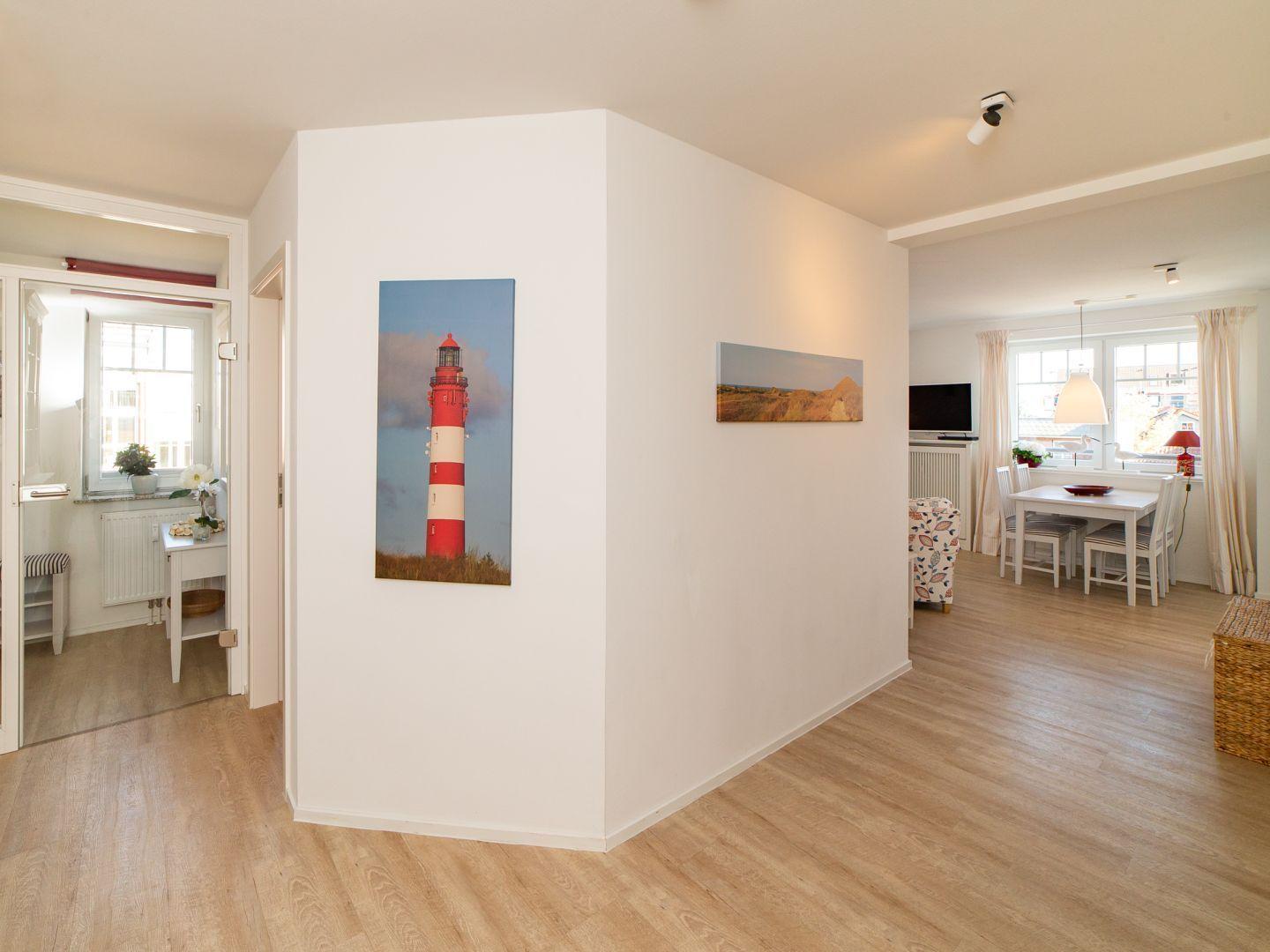 Wohnung mit Essbereich, Wandbild eines Leuchtturms und Holzboden.