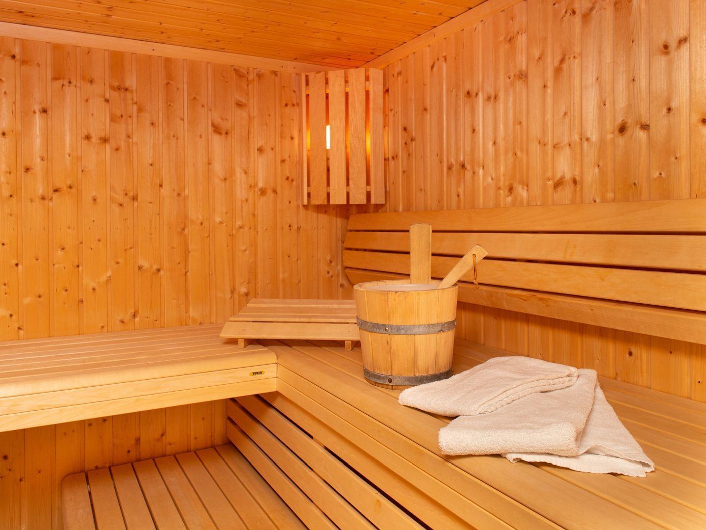 Sauna mit Holzbank, Eimer und Handtuch