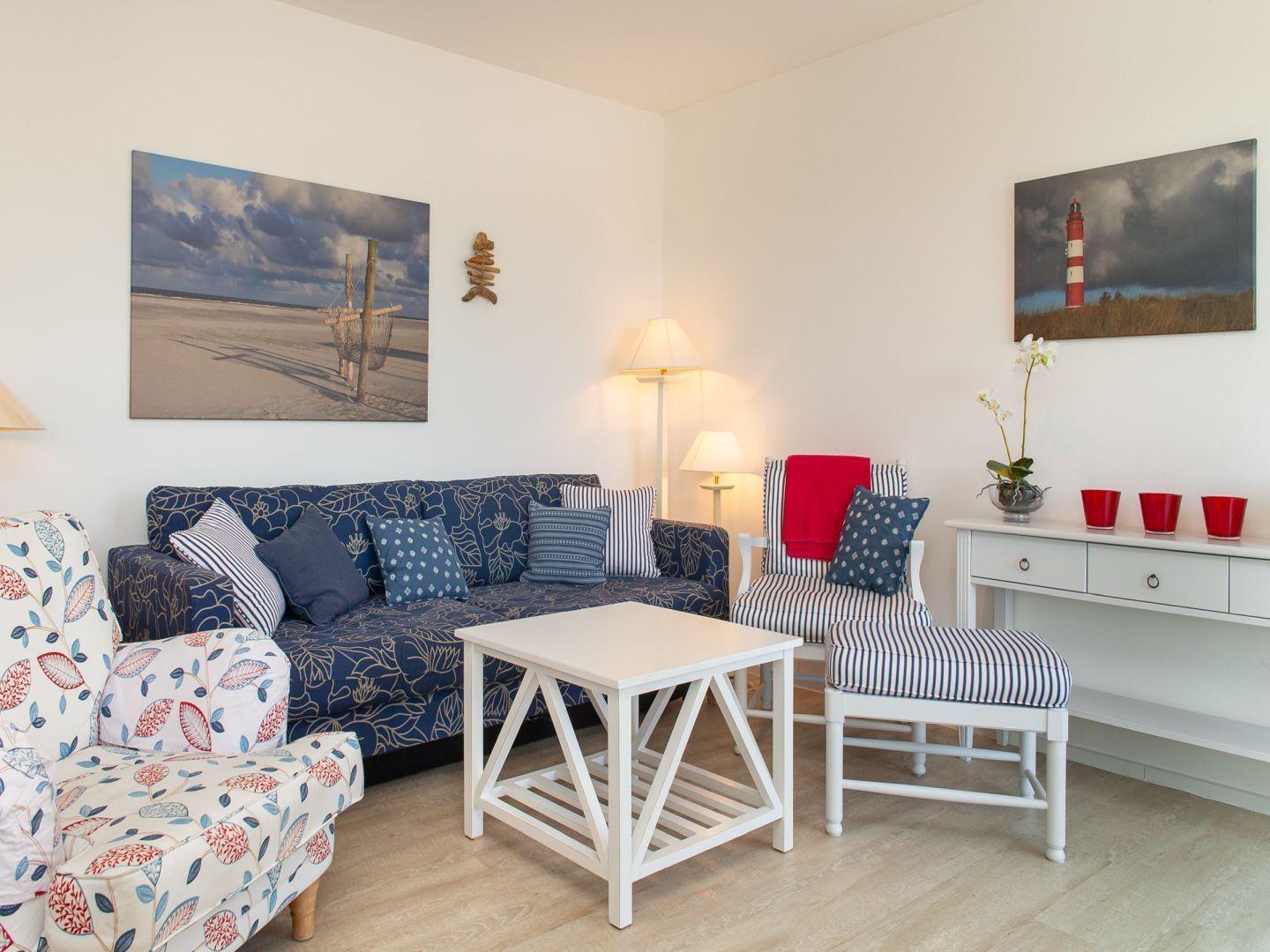 Wohnzimmer mit Sofa, Stühlen und Wandbildern