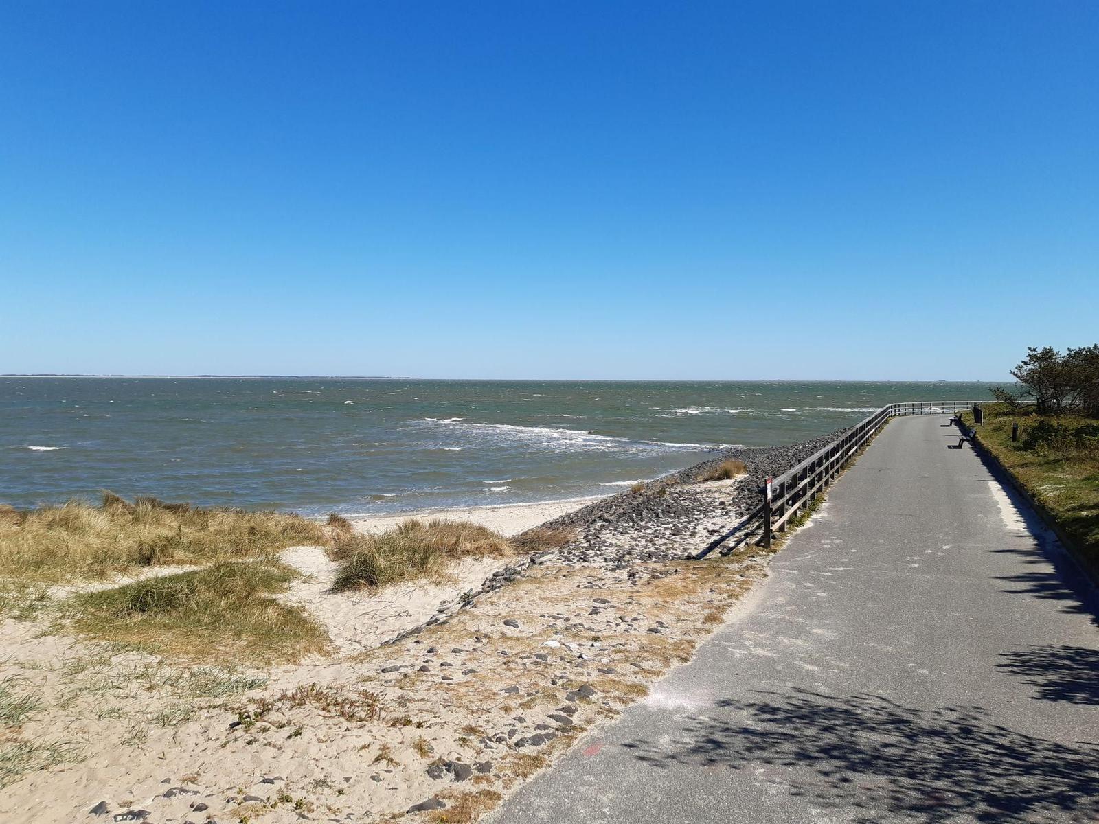 Meerstrand mit asphaltierter Promenade und Dünen