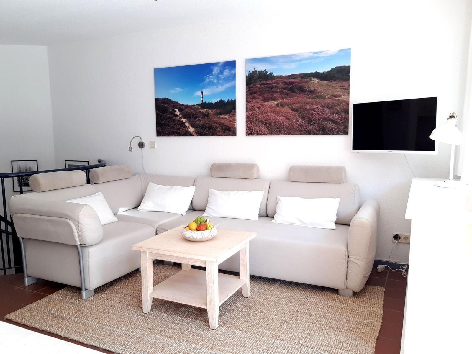 Wohnzimmer mit Sofa, Couchtisch und Wandbildern
