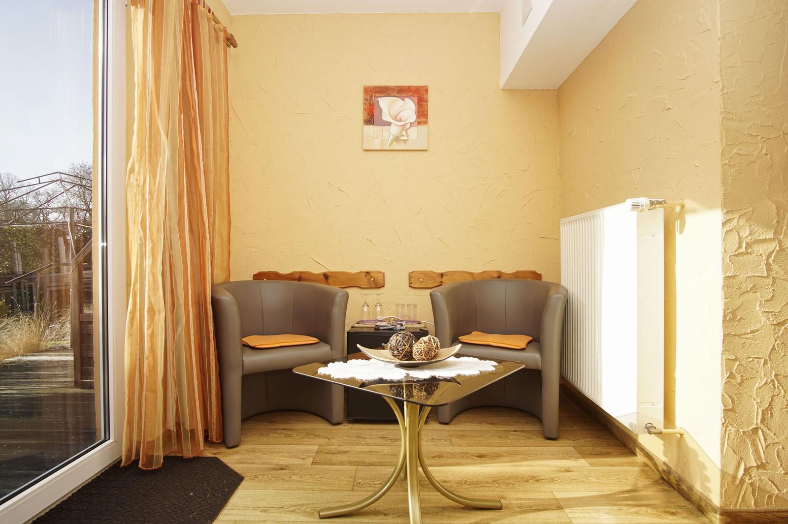 Zwei Sessel mit Kissen, Tisch und Bild an Wand