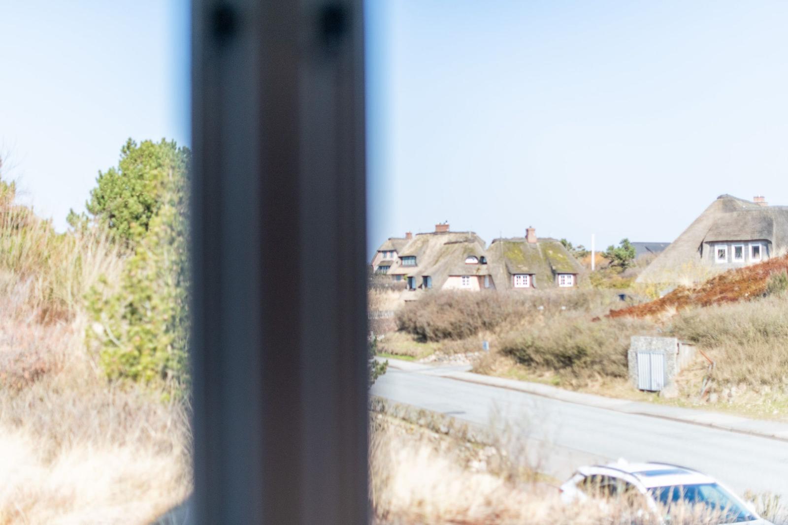 Ansicht durch Fenster auf Dörfer mit Strohdächern und Straße