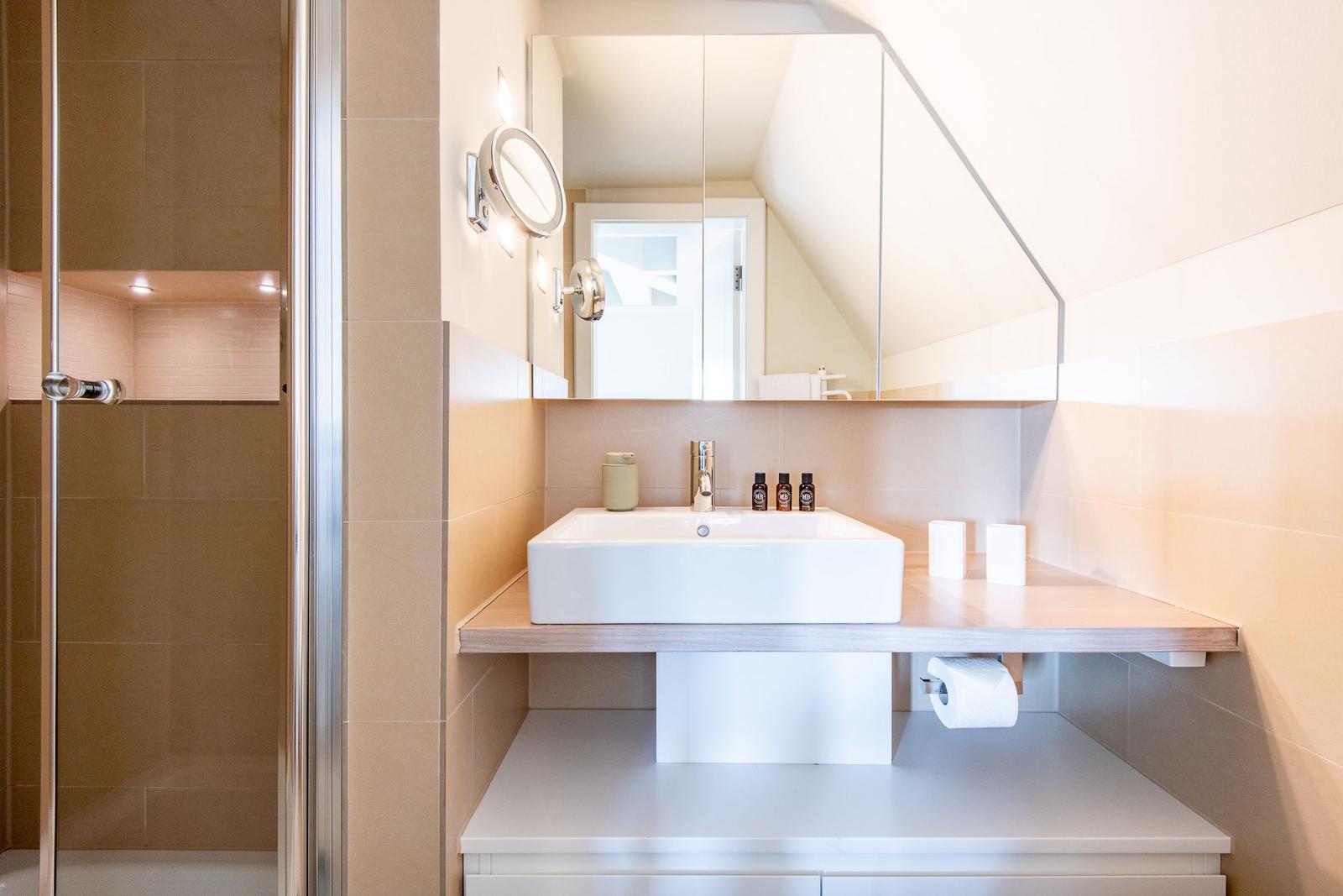 Bad mit Dusche, Waschbecken und Spiegel