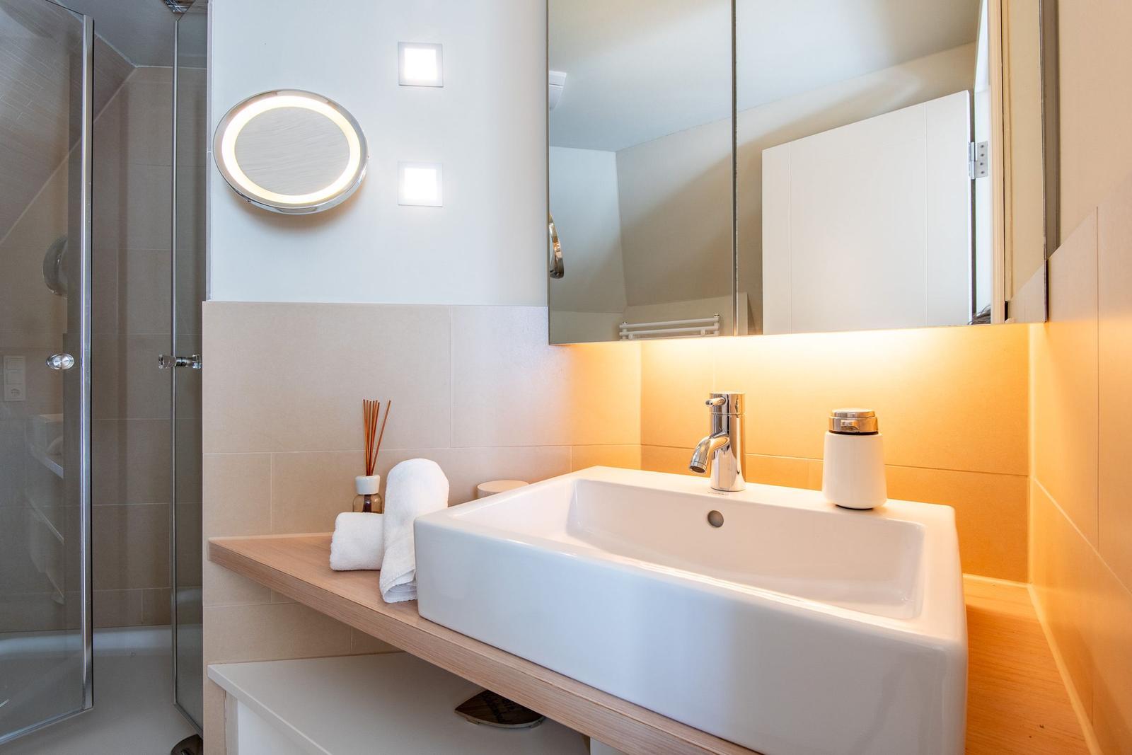 Bad mit Dusche, Waschbecken und Spiegel